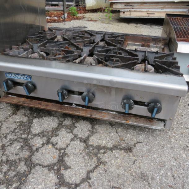 Radiance 6-burner natural gas range, missing one grate, measuring 36x30x12 inches, visible wear on knobs and surface.