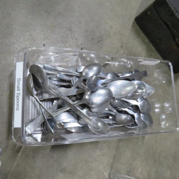 Assorted small spoons in a clear plastic container, good condition. Tag reads "Small Spoons."