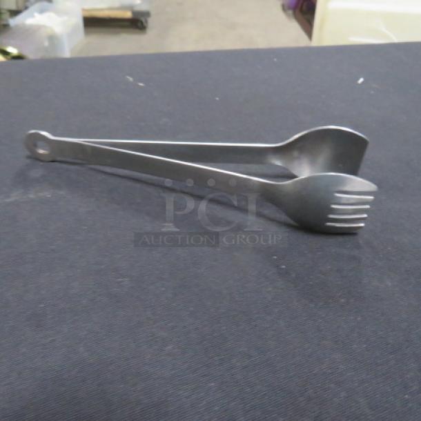 Stainless steel tong, model 6XBID, features scalloped edges, durable, in good condition. Ideal for kitchen use.