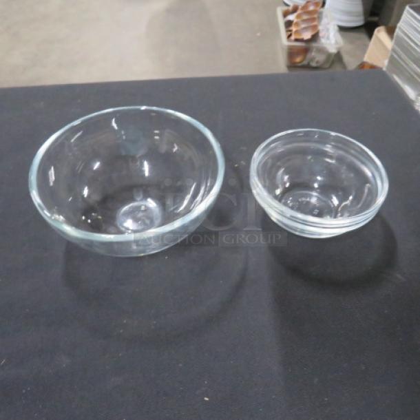 Assorted clear glass ramekins in two sizes; gently used, smooth glass finish, ideal for baking or serving.