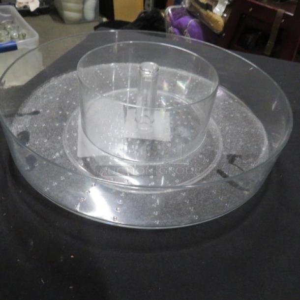Clear poly rotating storage tray, new condition, circular design with raised center handle, suitable for organizing items.