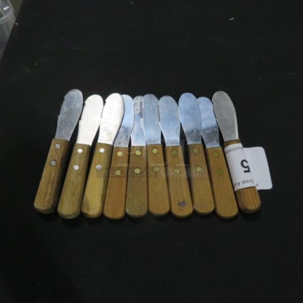 Set of 10 spreaders with wooden handles and stainless steel blades, showing slight wear. Auction tag marked "5".