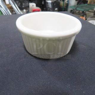 White ceramic ramekin with a ribbed exterior, in good condition. No visible chips or cracks, ideal for baking or serving.