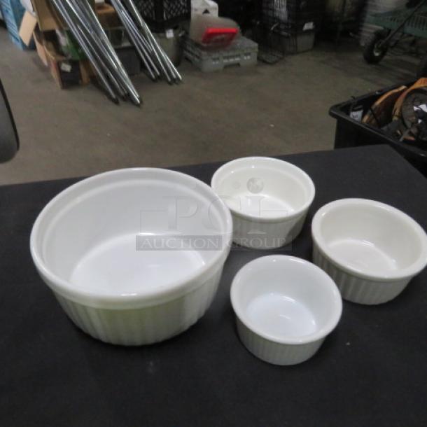 Assorted size white ramekin set, four pieces, in excellent condition. Ribbed design, ideal for baking or serving dishes.