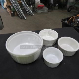 Assorted size white ramekin set, four pieces, in excellent condition. Ribbed design, ideal for baking or serving dishes.