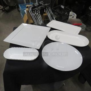 Assorted white ceramic serving dishes, set of five; includes oval, rectangular, and square plates; excellent condition.