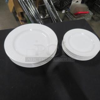 Lot of matching white dishes, including large and small plates, with textured rims. Good condition.