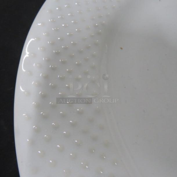 White dish with textured dot pattern on rim, part of a matching set; pristine condition.