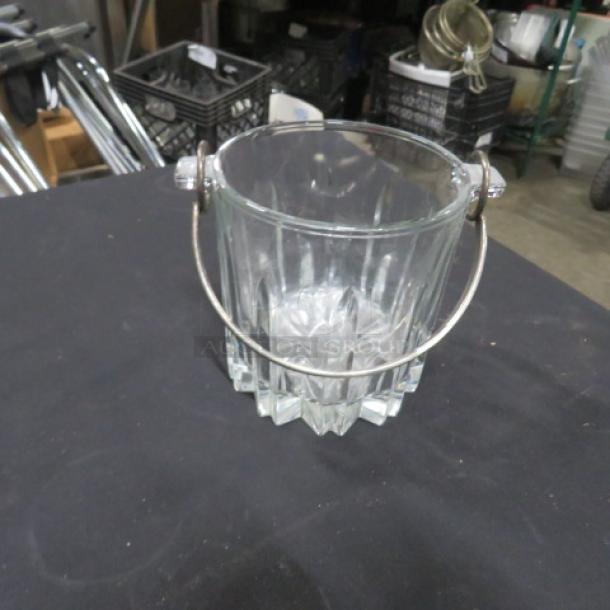 Cut glass ice bucket with a metal handle. Features vertical faceted design. In good condition, no visible markings.
