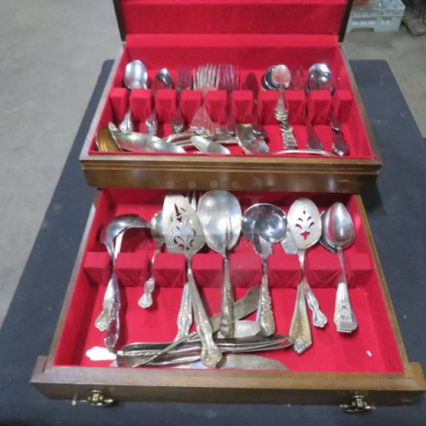 Wooden flatware box with one drawer, containing vintage flatware. Silver utensils on red velvet lining, used condition.