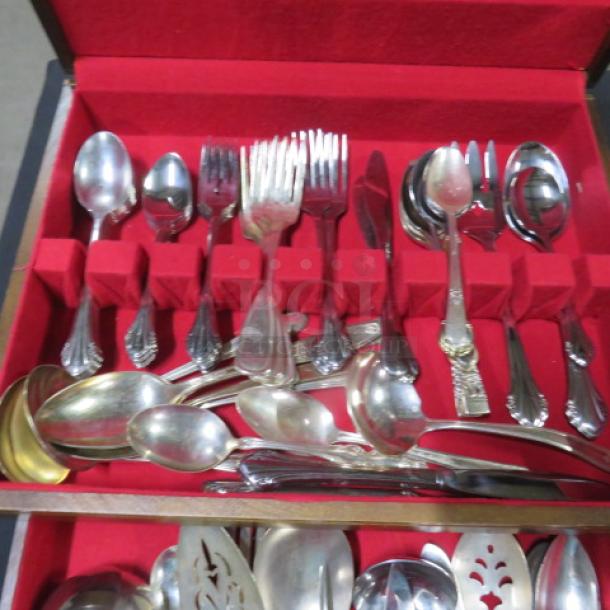 One wooden flatware box with one drawer, contains vintage flatware set. Red interior, assorted spoons, forks, ladles.