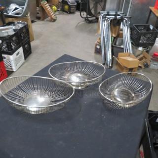 Set of three wire baskets with a silver finish, round shape, open design, good condition, ideal for decorative or functional use.