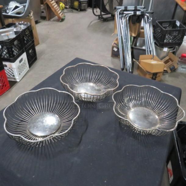 Silver wire baskets, set of three, intricate floral design, used condition, metal construction, displayed on black surface.