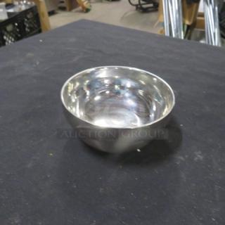 Shiny 4-inch metal bowl with a polished finish on a black surface. No visible markings or labels.