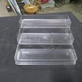 Clear 3 tier poly shelf, 4XBID model, in excellent condition. Each tier features a ribbed surface for stability. Ideal for organizing small items.