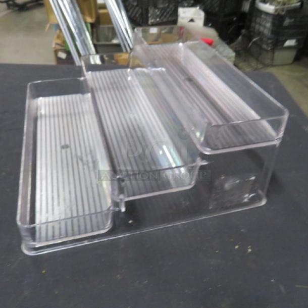 Clear 3-tier poly shelf, used condition, with a ribbed surface for display organization.