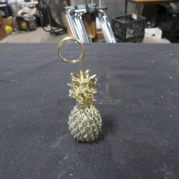 Gold pineapple place card holder with spiral clip, part of a lot of 19. Elegant design, good condition. Ideal for events.