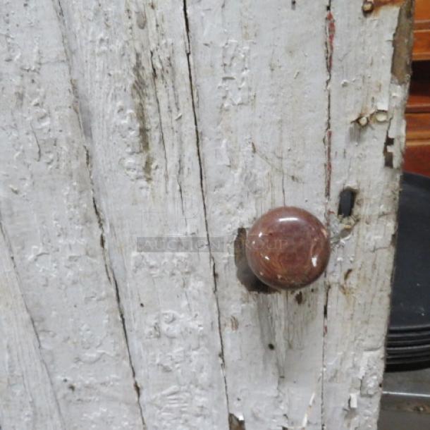 Vintage decorative door, 41x90 inches, weathered wood with chipping paint, round brown knob, rustic condition.