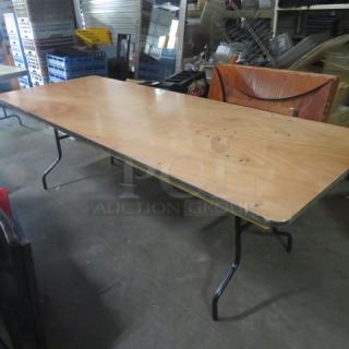 Wooden folding table, 96x36x30 inches, sturdy metal legs, natural wood finish, good condition, ideal for versatile use.