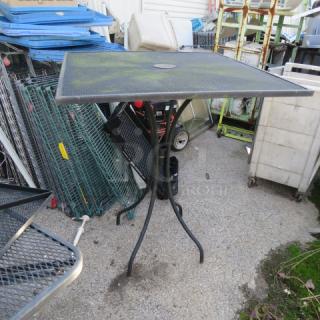 Black metal bar height patio table, 36x36x42 inches, square top with umbrella hole, sturdy legs, outdoor use.