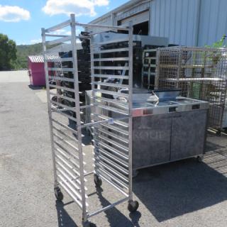 Aluminum speed rack on casters, 20.5x26x69 inches, holds trays, sturdy, used condition. Ideal for commercial kitchens.