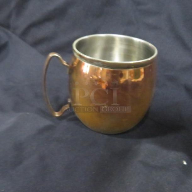 Copper Moscow Mule mug, stainless steel interior, side handle; reflective finish, gently used condition. Marked 4XBID.