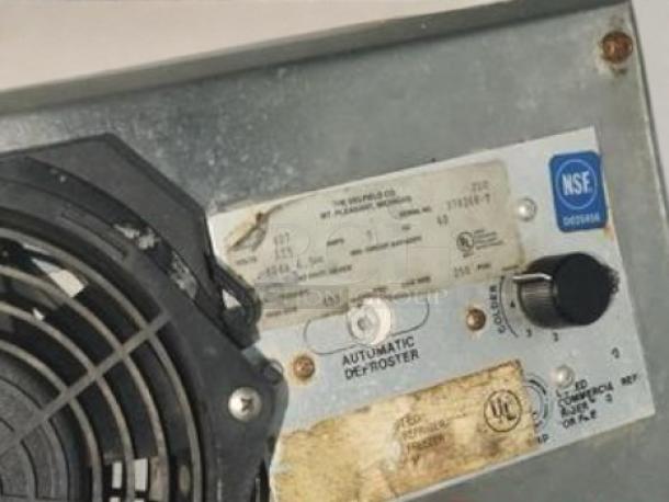 Delfield 3024-S undercounter freezer label with specifications and defrost controls. Model and compliance markings visible.