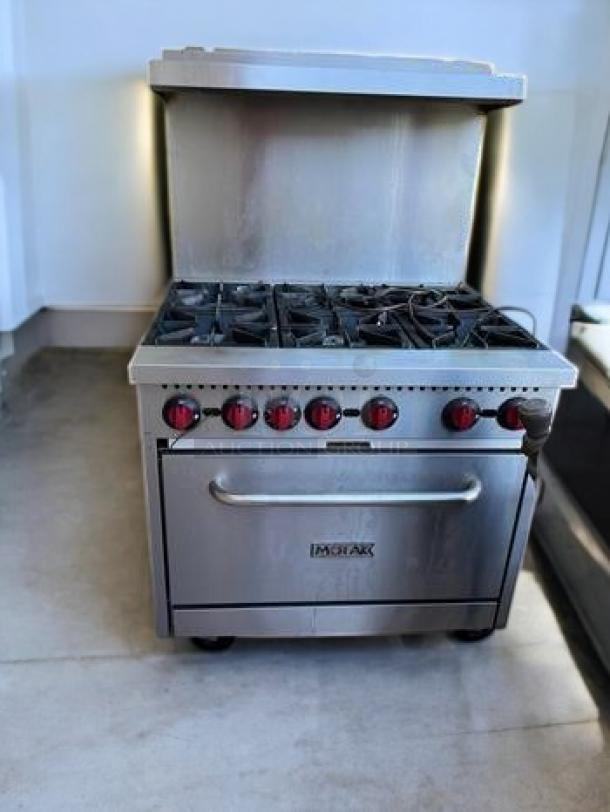 6-burner commercial gas range with oven, great condition, fully tested, heavy-duty line, natural gas, red control knobs.