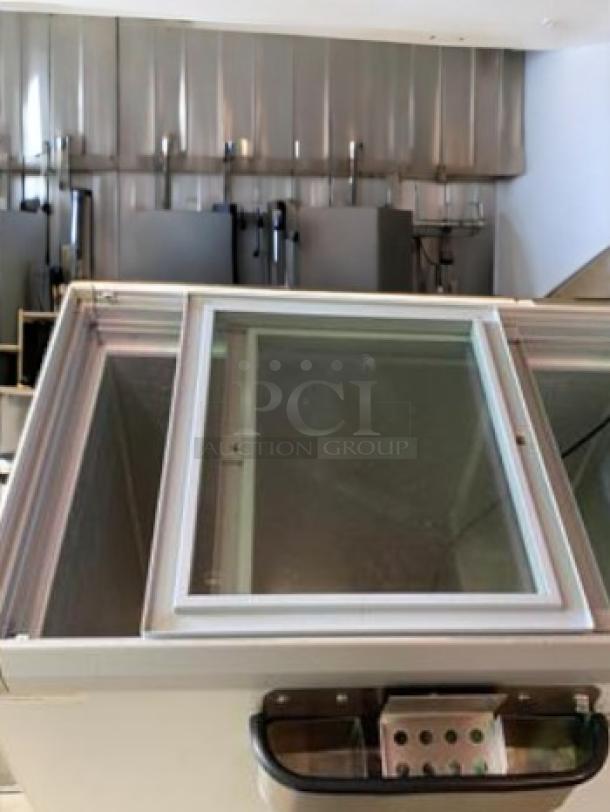 Commercial sliding glass top chest freezer in outstanding condition, 115V, fully tested and working. Ideal for ice cream and beverages.