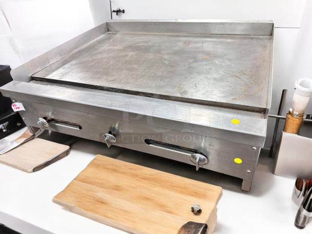 Commercial Grade 36" stainless steel flat top gas griddle in superb condition, fully tested and working, with control knobs.