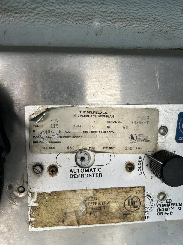 Label on Delfield 407 undercounter freezer, specifying model, voltage, UL listing, and automatic defroster details.