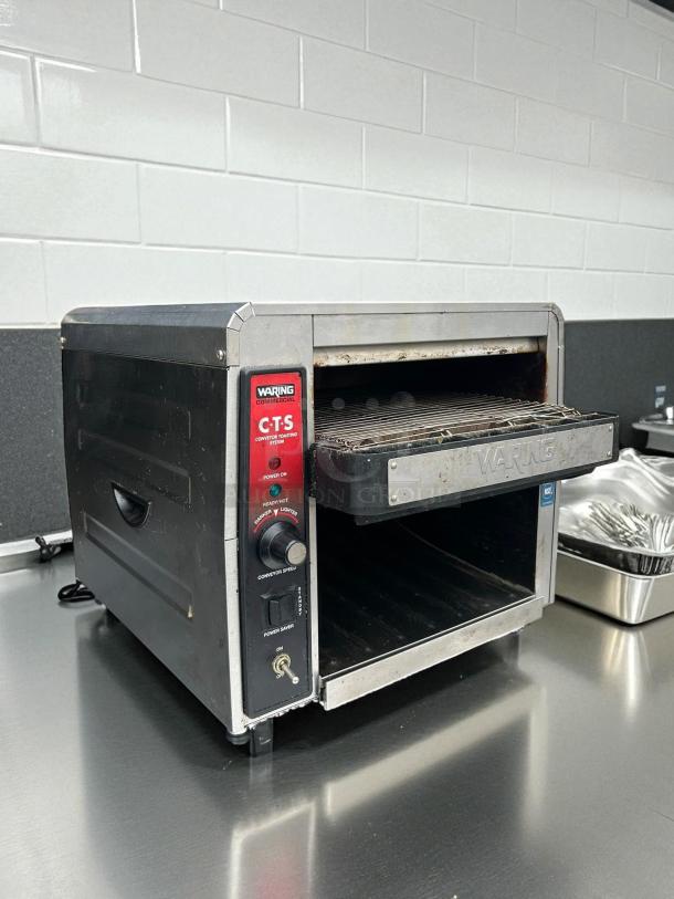 Waring CTS1000 commercial conveyor toaster, 120V, tested and working, stainless steel, signs of use, power and speed controls visible.