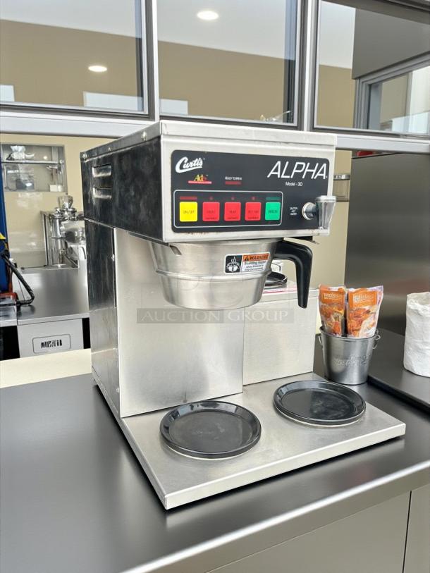 Curtis Alpha 3DR Coffee Brewer with three lower warmers, 120/220V, great condition, tested and working, visible control panel.