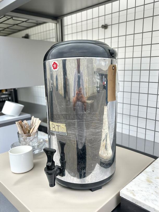AUNG HUA heat-preservation tea barrel in great condition, reflective finish with black lid, visible spout, and attached label.