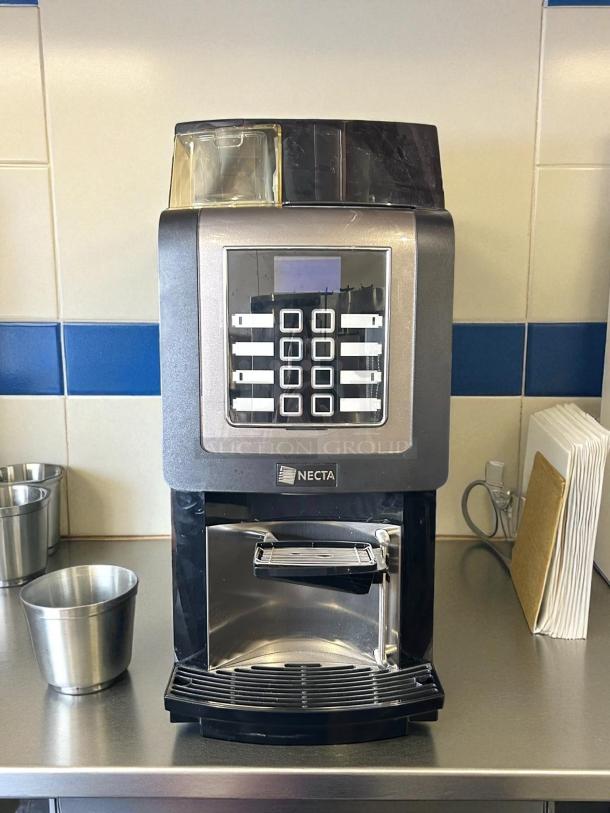 Necta Kometa Automatic Espresso Machine, tested and working. Silver and black finish, keypad interface, 120V/60Hz.
