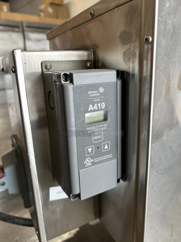 Johnson Controls A419 digital thermostat, watertight Type 4X, gray, mounted on metal panel, UL listed.
