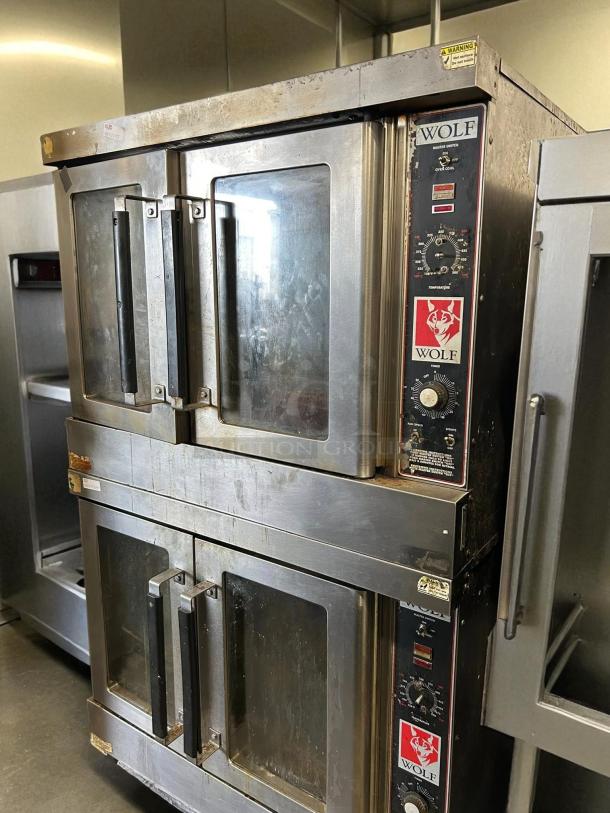 Wolf commercial gas double-deck convection oven, stainless steel, visible wear, tested and working, control panel with dials.