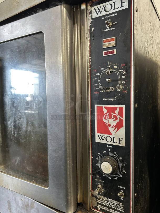 Wolf commercial gas double-deck convection oven, standard depth, tested and working. Features temperature dials and logo.