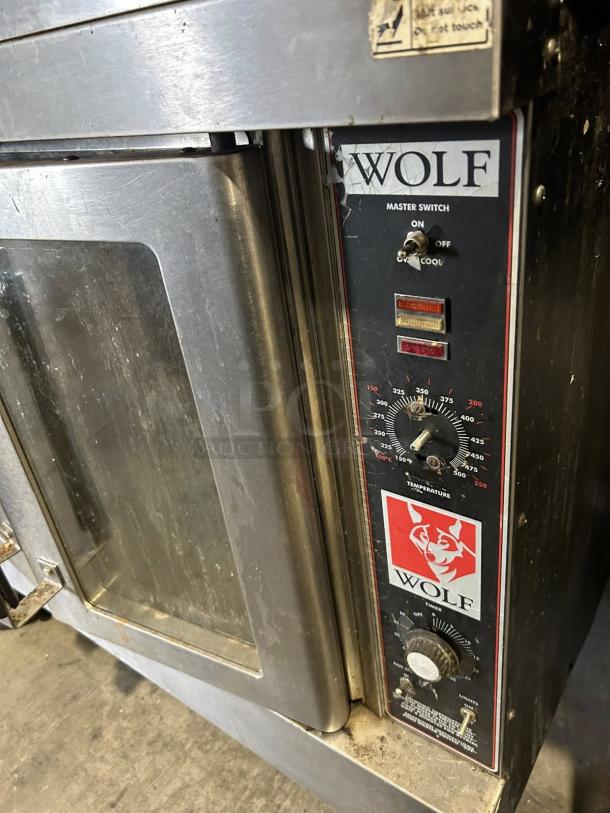 Wolf commercial gas double-deck convection oven in tested working condition, features temperature controls and Wolf branding.
