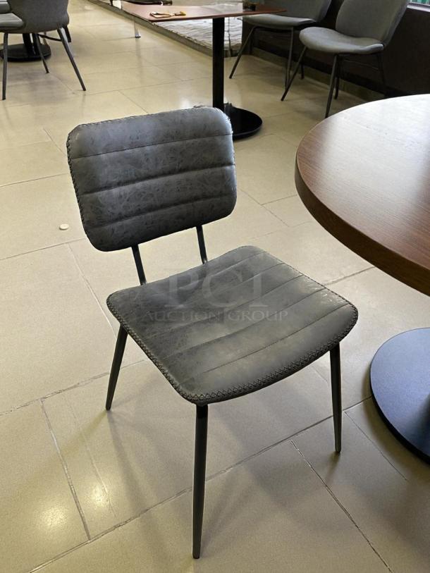 Black cushioned chair in excellent condition, features a quilted design with sturdy metal legs, ideal for dining or office use.