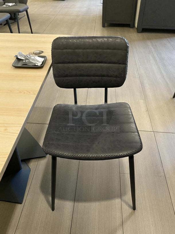 Black cushioned chair in excellent condition, sleek design, padded seat and backrest, sturdy metal legs.