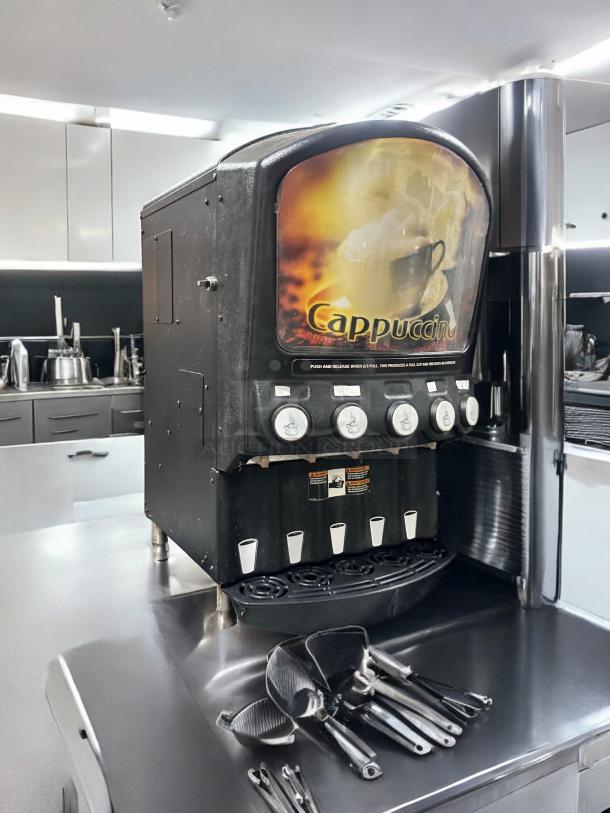 Grindmaster PIC5 beverage dispenser, 5 flavor, excellent condition, black, 120V, front label reads "Cappuccino," tested and working.