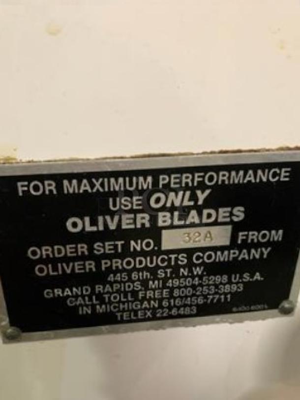 Label on Oliver 711 commercial bread slicer, specifying use of Oliver blades, with company contact details.