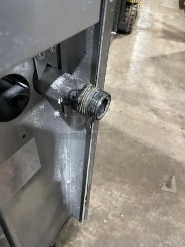 Close-up of the connection on a U.S. Range stainless steel 10 burner range. Shows natural gas fitting, part of larger appliance.
