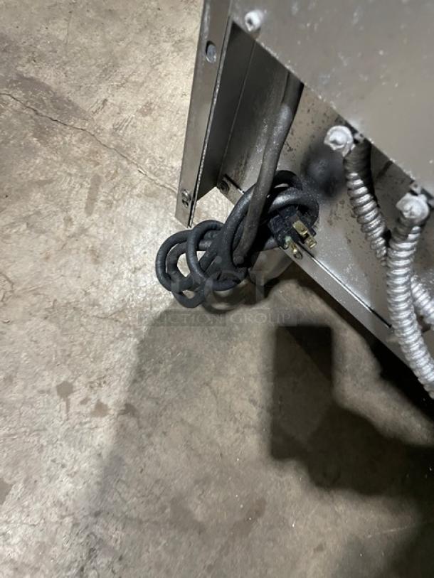Electrical cords and wiring of U.S. Range stainless steel natural gas 10-burner range with double oven combo.