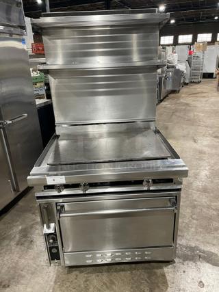 Jade Range 36" stainless steel flat top range/oven combo. Features backsplash, double shelves, and wired oven rack. On casters.