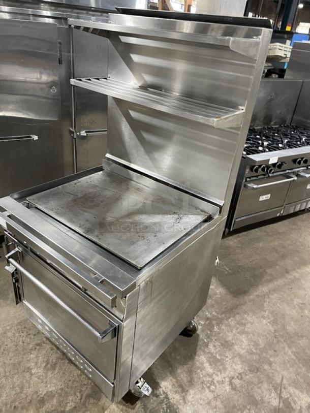 Jade Range 36" stainless steel flat top range/oven combo with backsplash, double overhead shelf, and wired oven rack on casters.