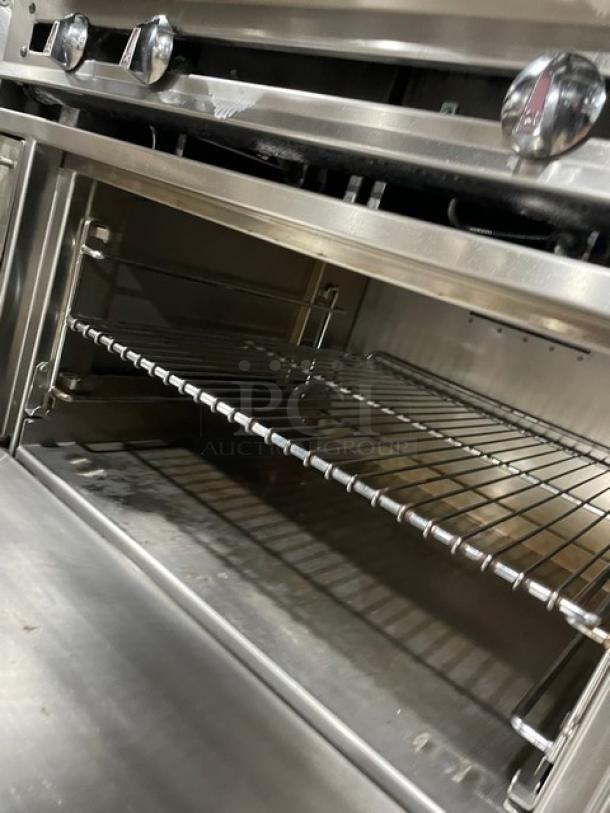Jade Range 36" stainless steel flat top range/oven combo, features backsplash, double overhead shelf, wired oven rack, on casters.