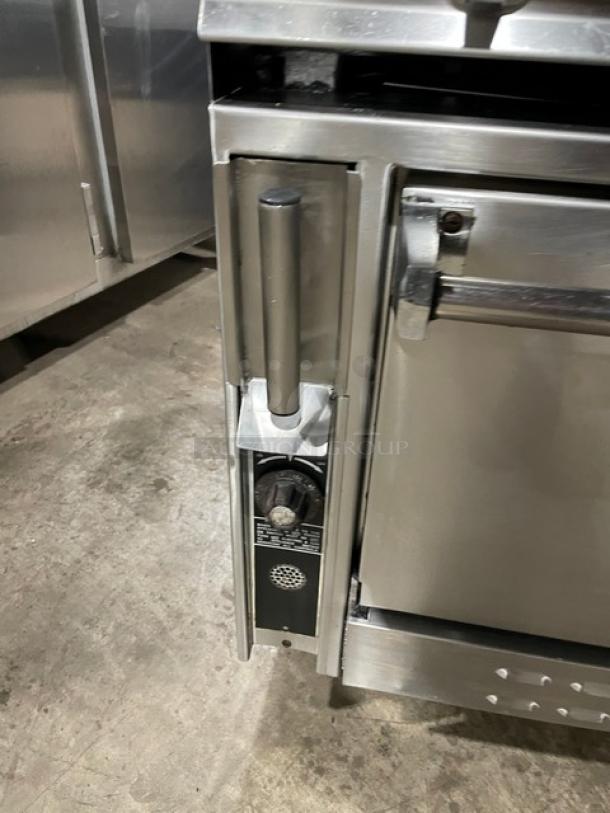 Jade Range 36" stainless steel flat top range/oven combo with backsplash, double shelves, and caster wheels. Used condition.