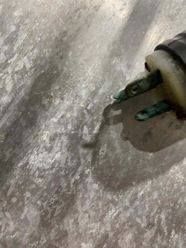 Close-up of a worn electrical plug against a textured background, likely part of the Metro C519CFCU holding cabinet.